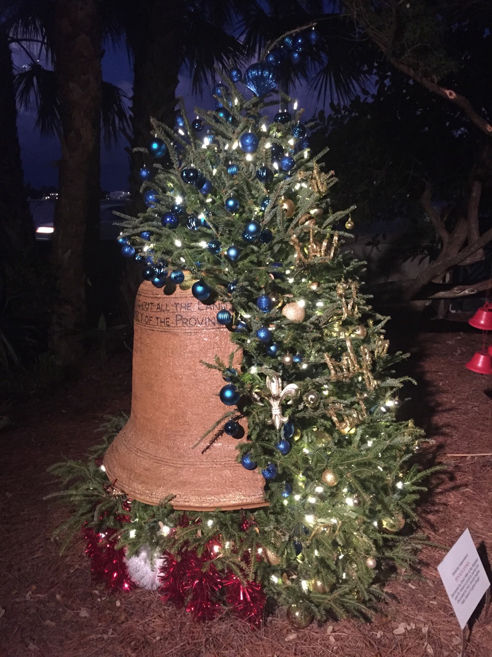 A blue-and-silver holiday tree arranged in a rustic sack.