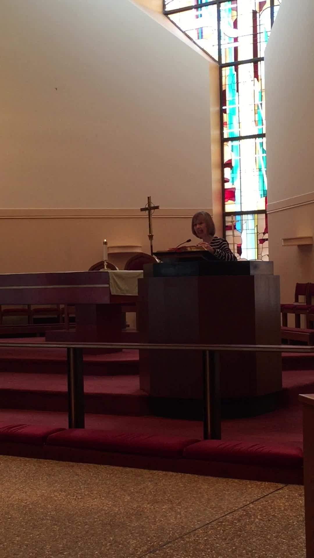 Poster frame showing an interior with a lectern, pews, and a stained-glass window.