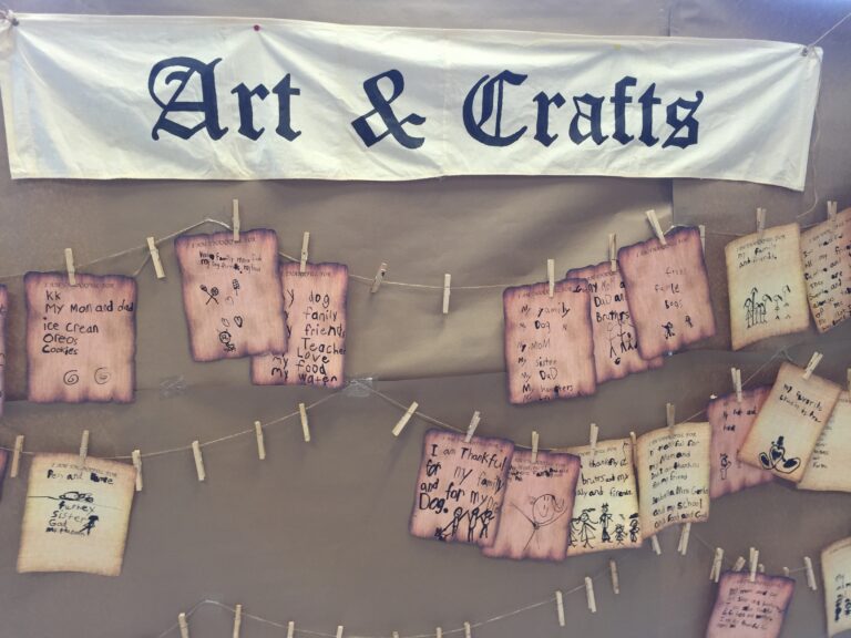 An Art & Crafts sign above handmade notes clipped to lines.