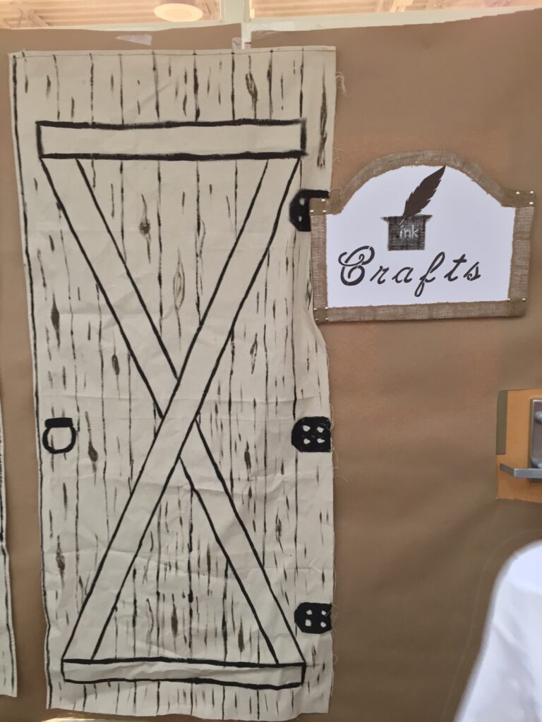 A handmade rustic door display beside a Crafts sign.