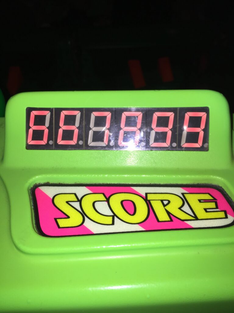 Close-up of a bright green game score counter with red digital numbers.