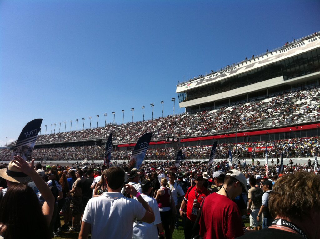 Crowds gathered in grandstands at a motorsports race.