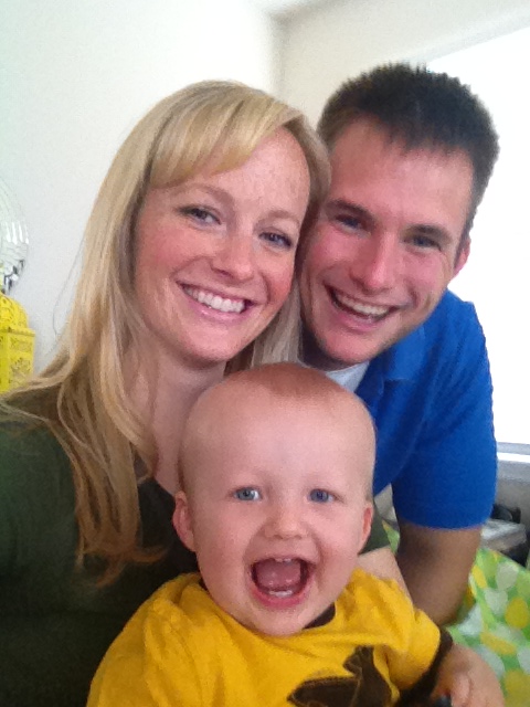 June Kuipers and Robert W. Kuypers smiling with their son Braden Kuipers as a baby in a yellow shirt.