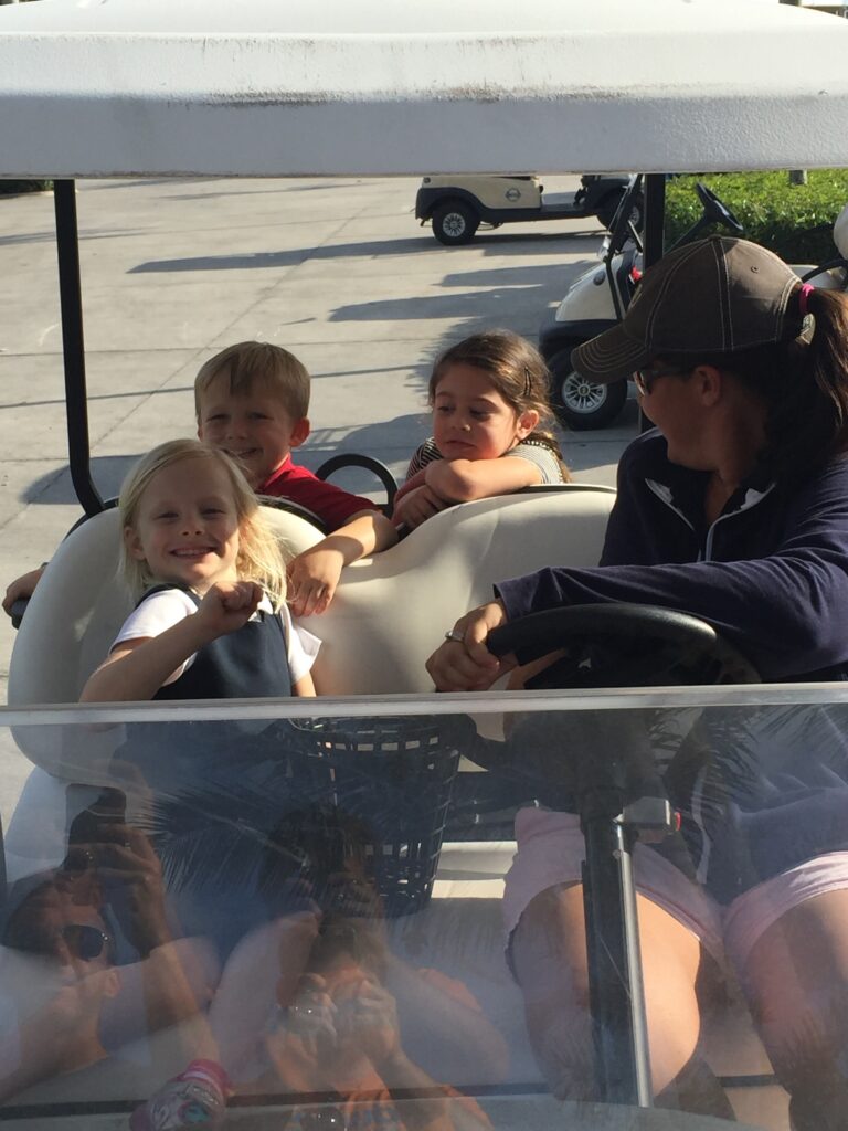 Family riding together in a golf cart.
