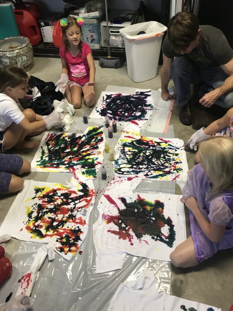 Children making colorful paintings together.