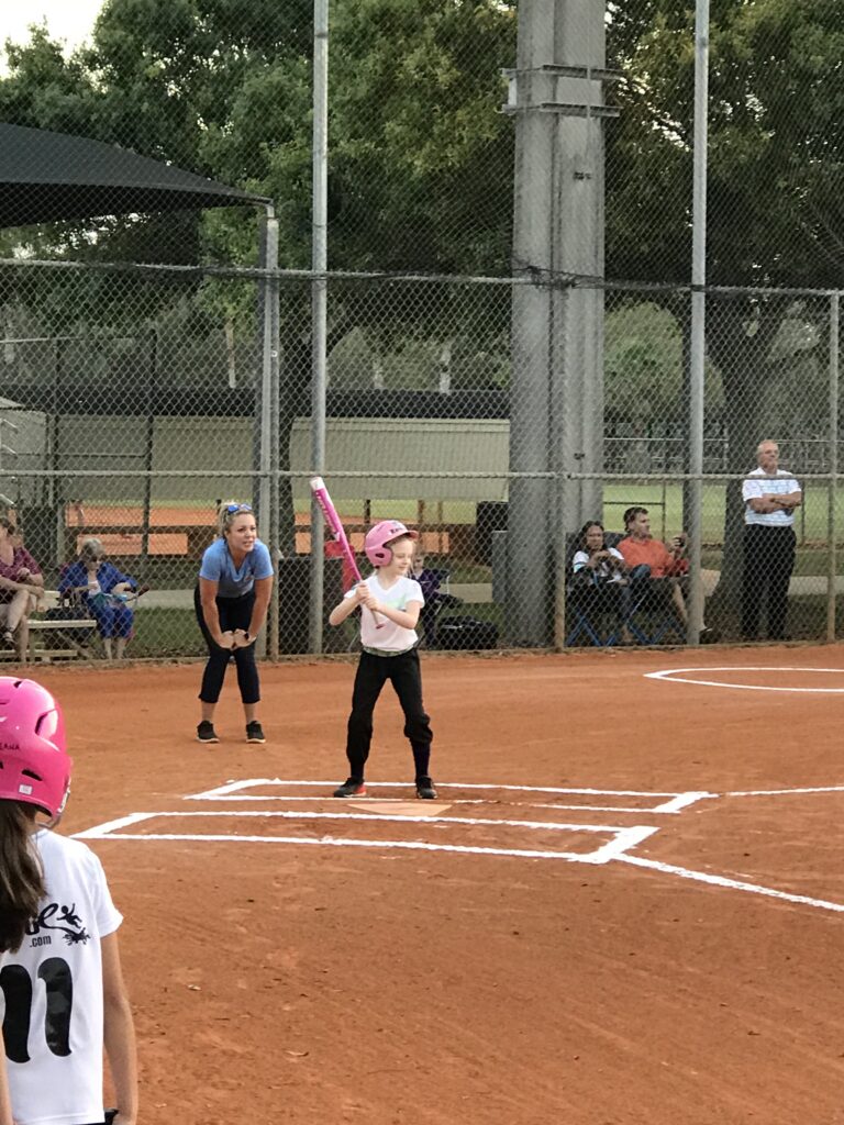 Young softball player at bat.