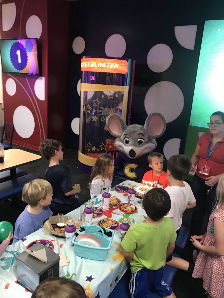 Children gathered around a birthday party table.