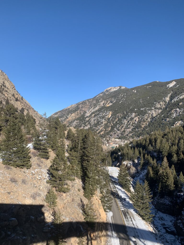 Snow-dusted mountain valley beneath a blue sky.