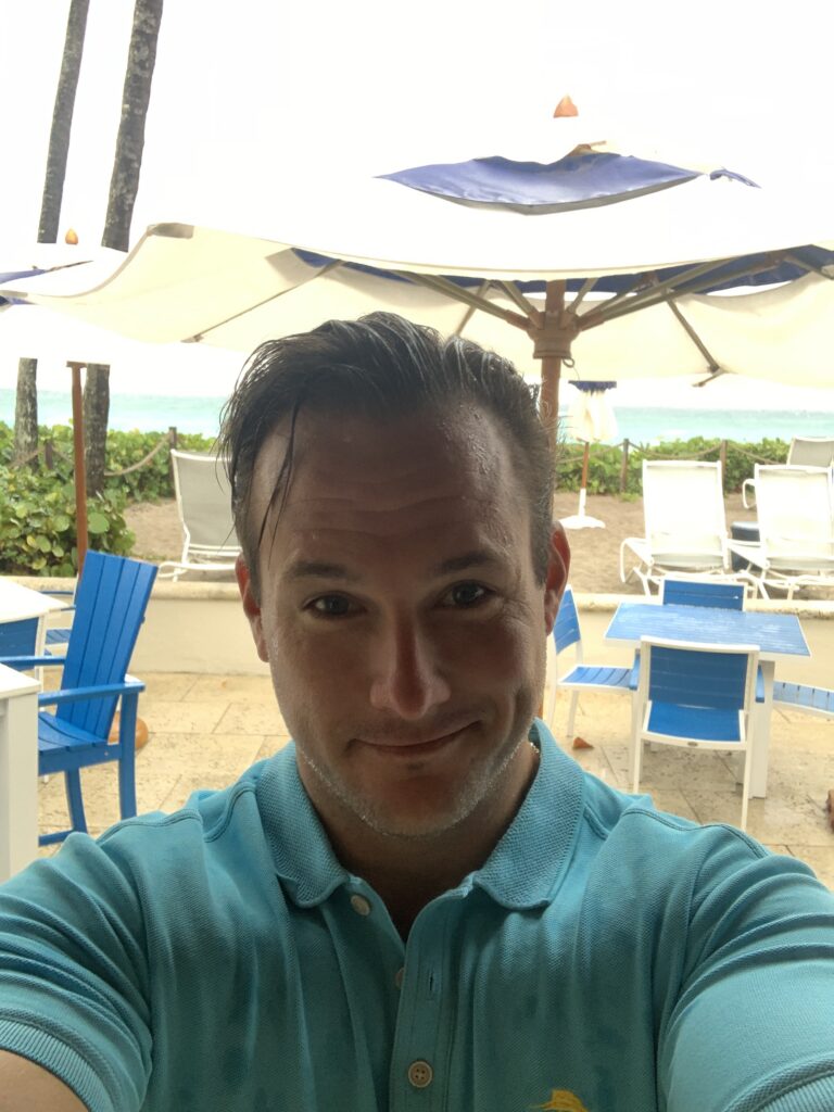 Man seated at an outdoor restaurant.