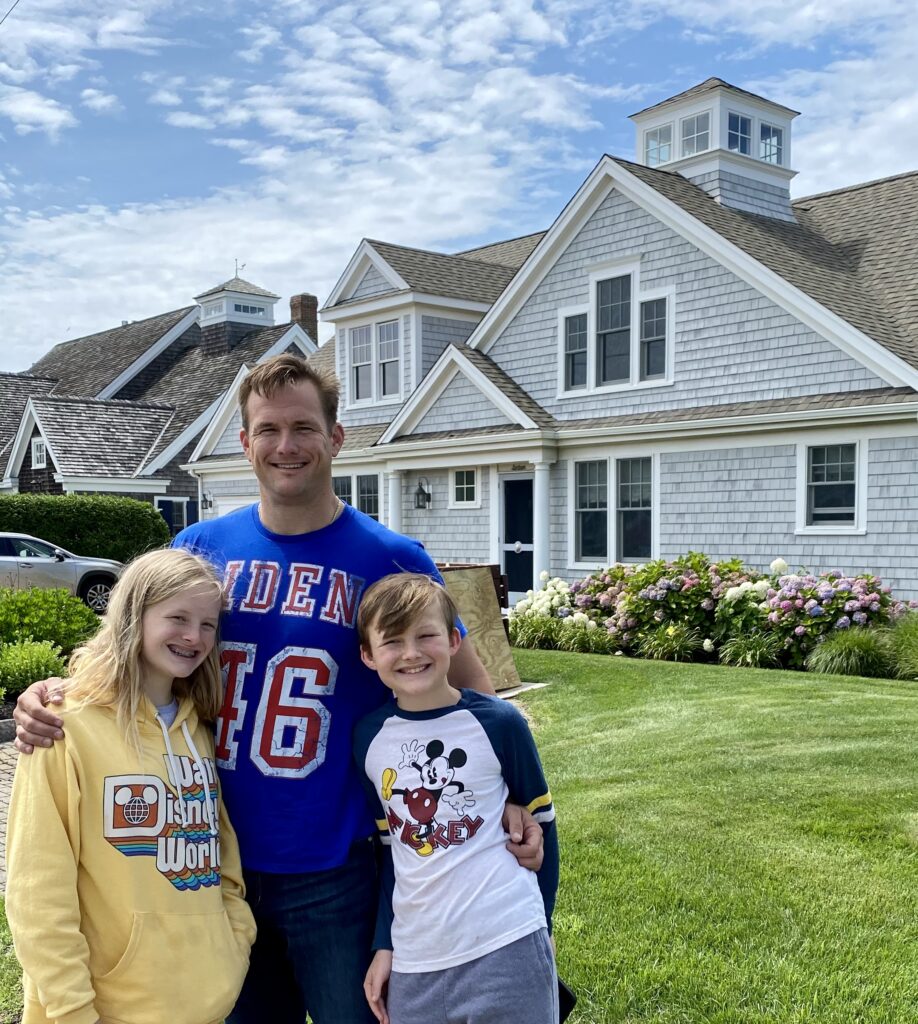 Adult and two children posing outdoors in sports shirts.