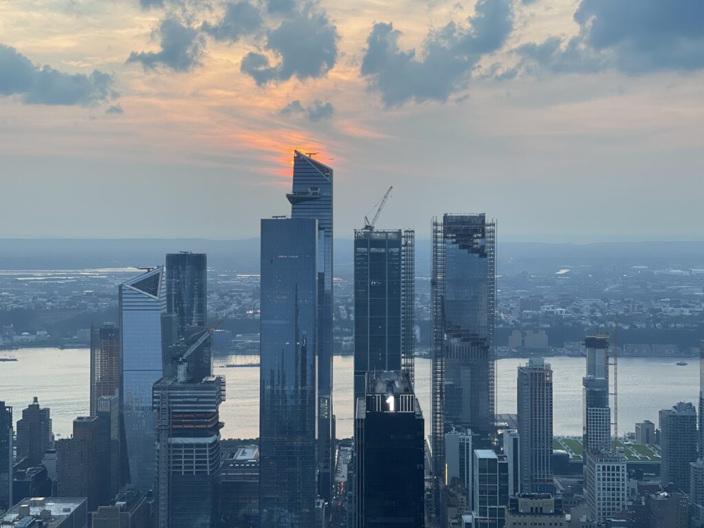 City skyscrapers beneath a glowing sunset.