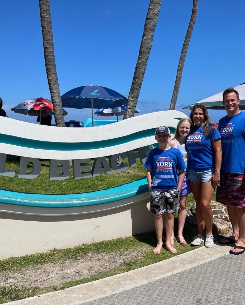 Family posing beside a colorful boat display.