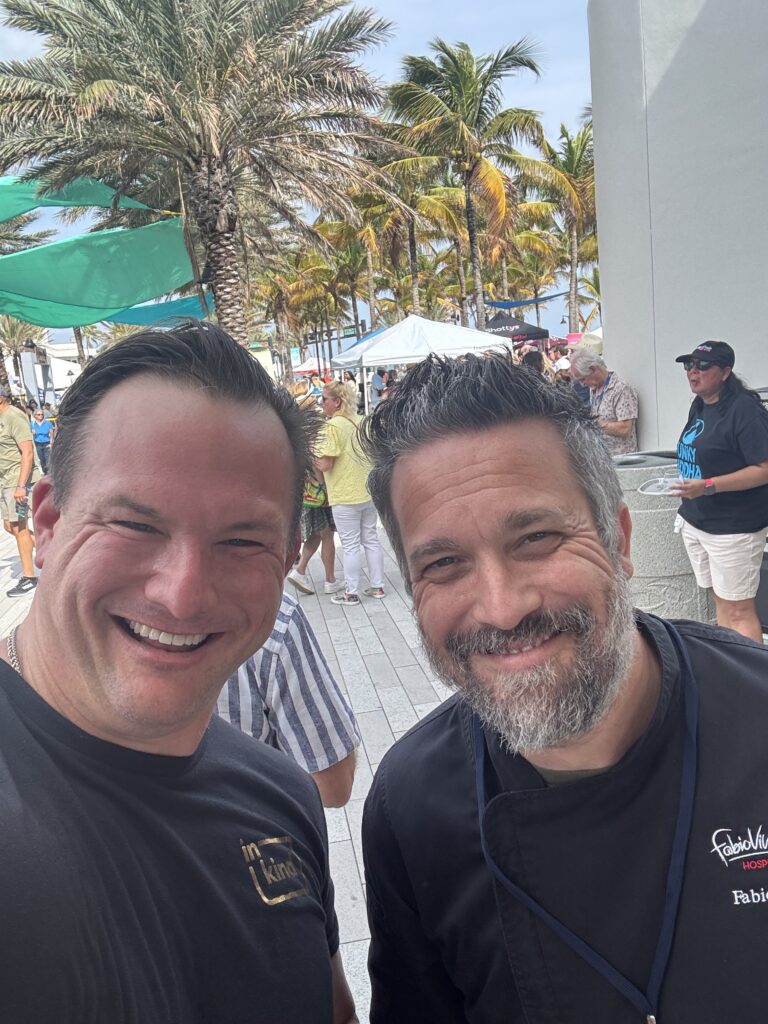 Two men smiling together outdoors.
