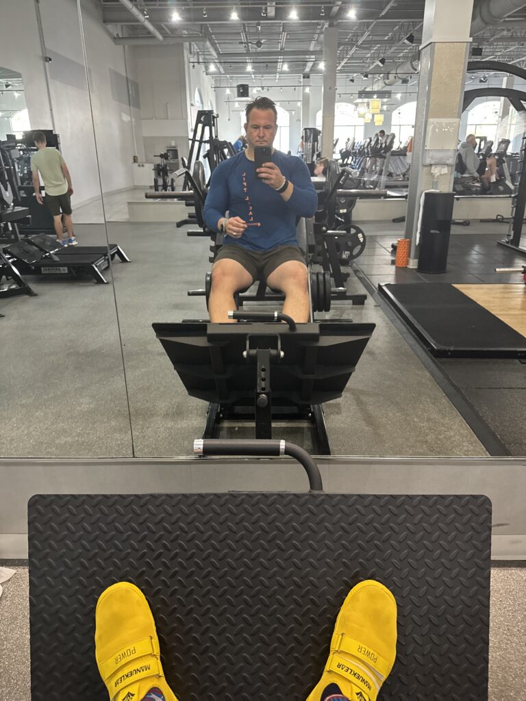 Man exercising on a rowing machine at the gym.