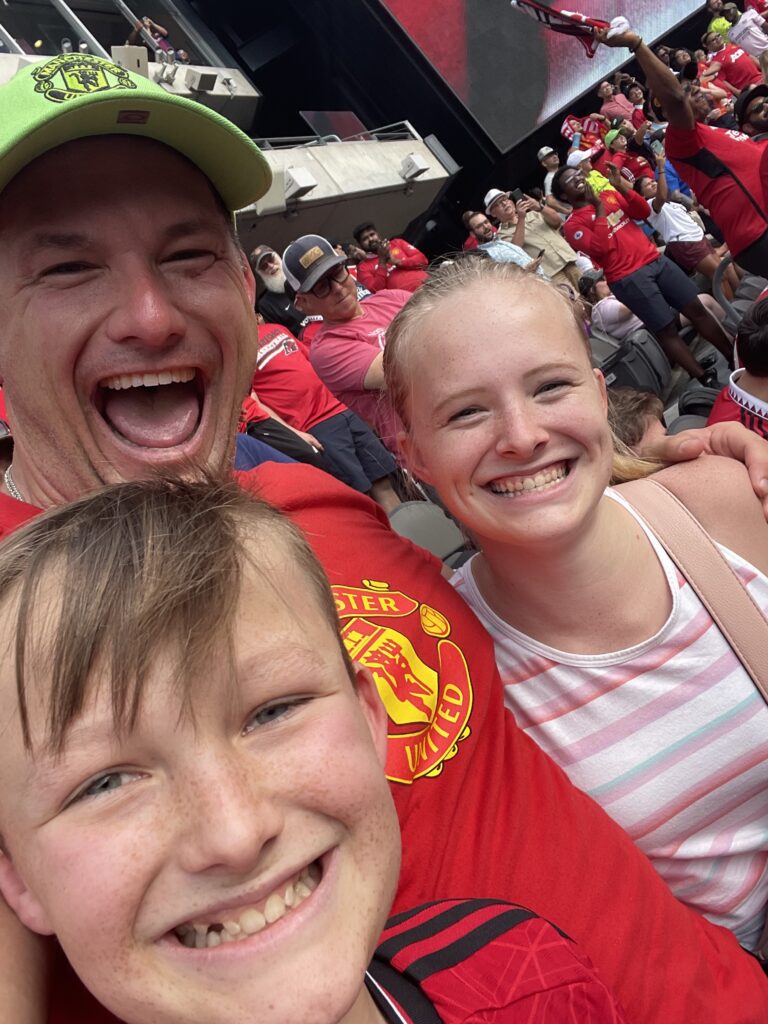 Robert W. Kuypers with Kenley and Braden cheering at Manchester United.