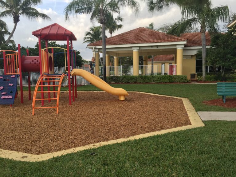 An empty neighborhood playground with slides and climbing equipment.