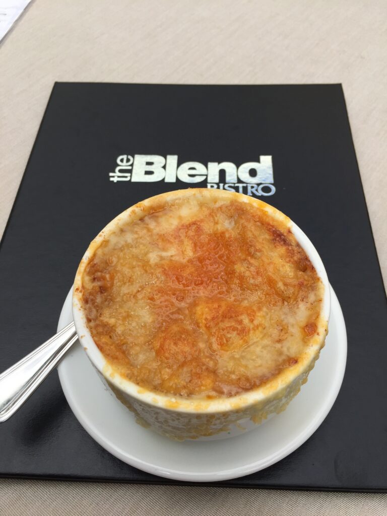Baked soup with a browned cheese top on a restaurant plate.