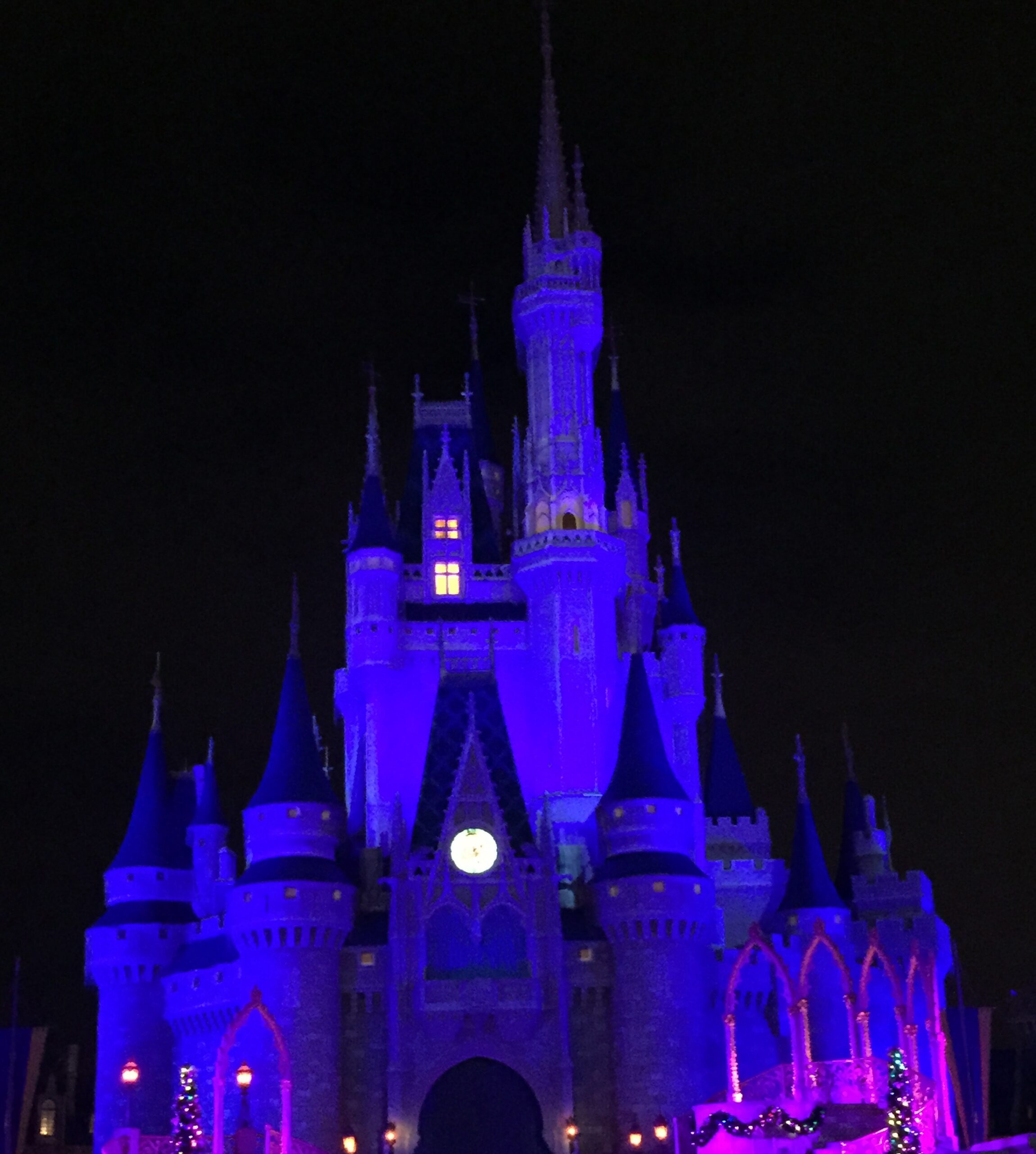 Cinderella Castle lit purple and pink against a dark sky.